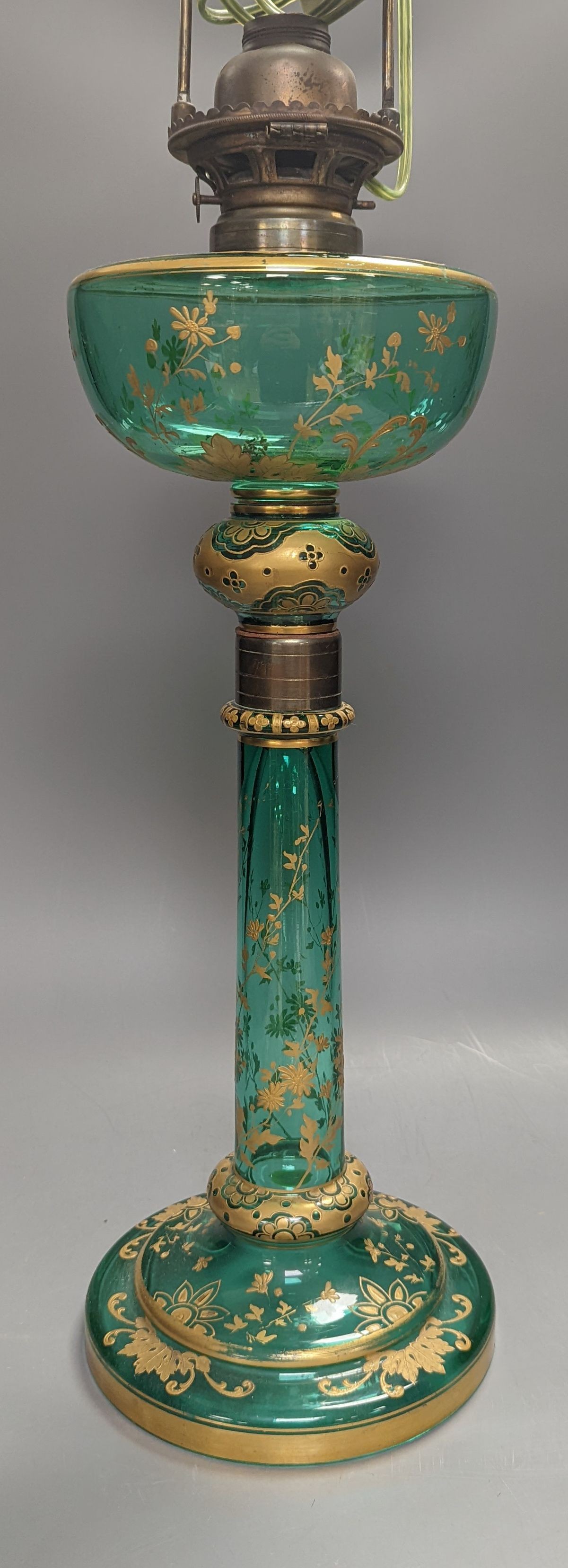 A tall Bohemian gilded green glass oil lamp, c.1900, height 48cm excl. light fitting